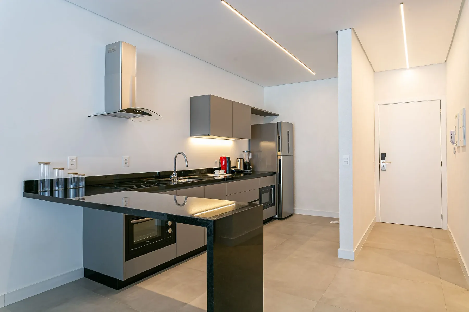A modern kitchen with dark countertops and stainless steel appliances.