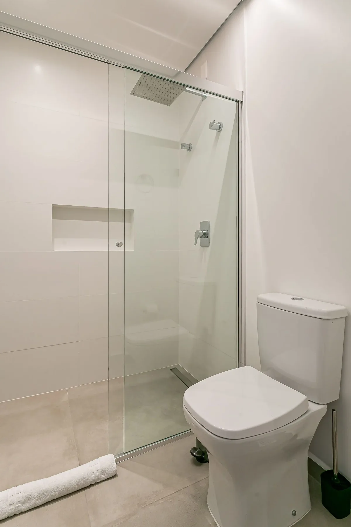 A modern bathroom with a glass-enclosed shower and toilet.
