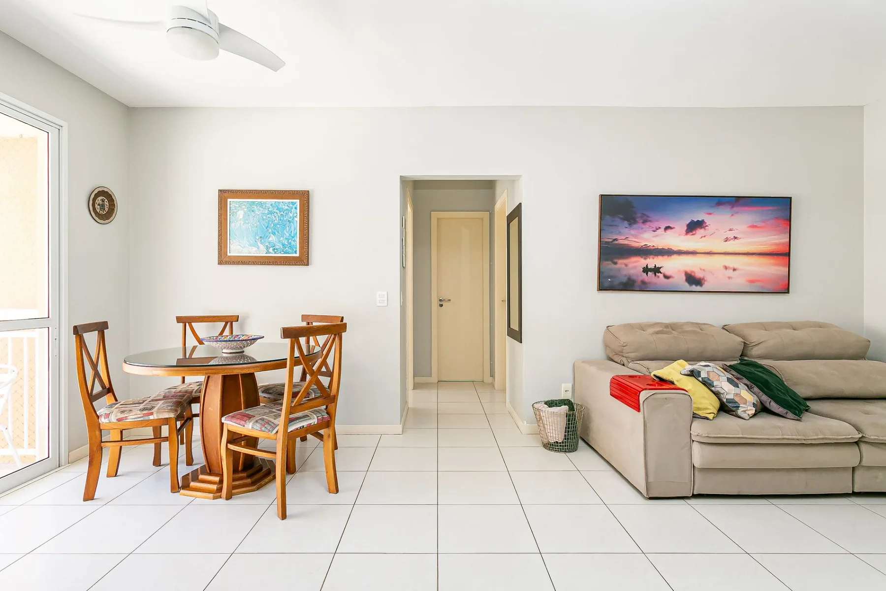 A living and dining area with seating, a table, and wall art.