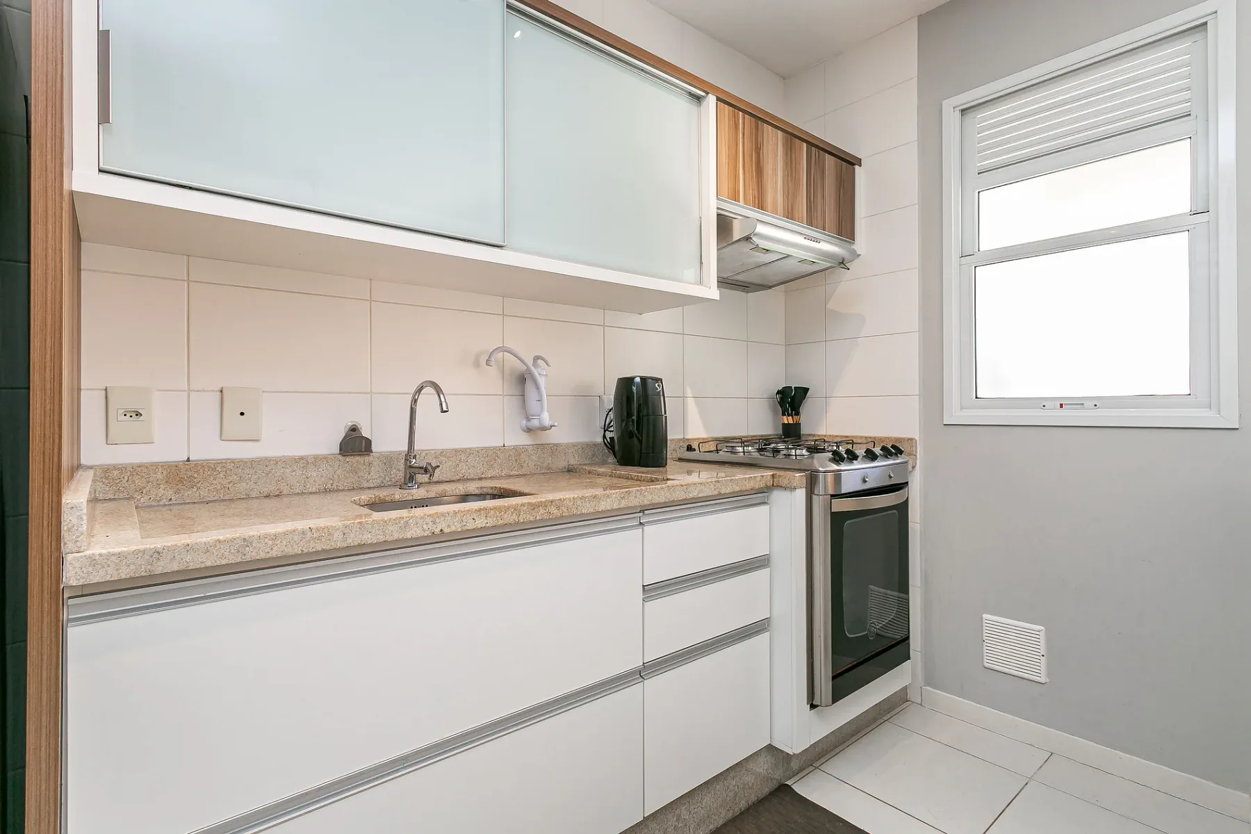 A bright kitchen with white cabinetry, a countertop, and a gas range.