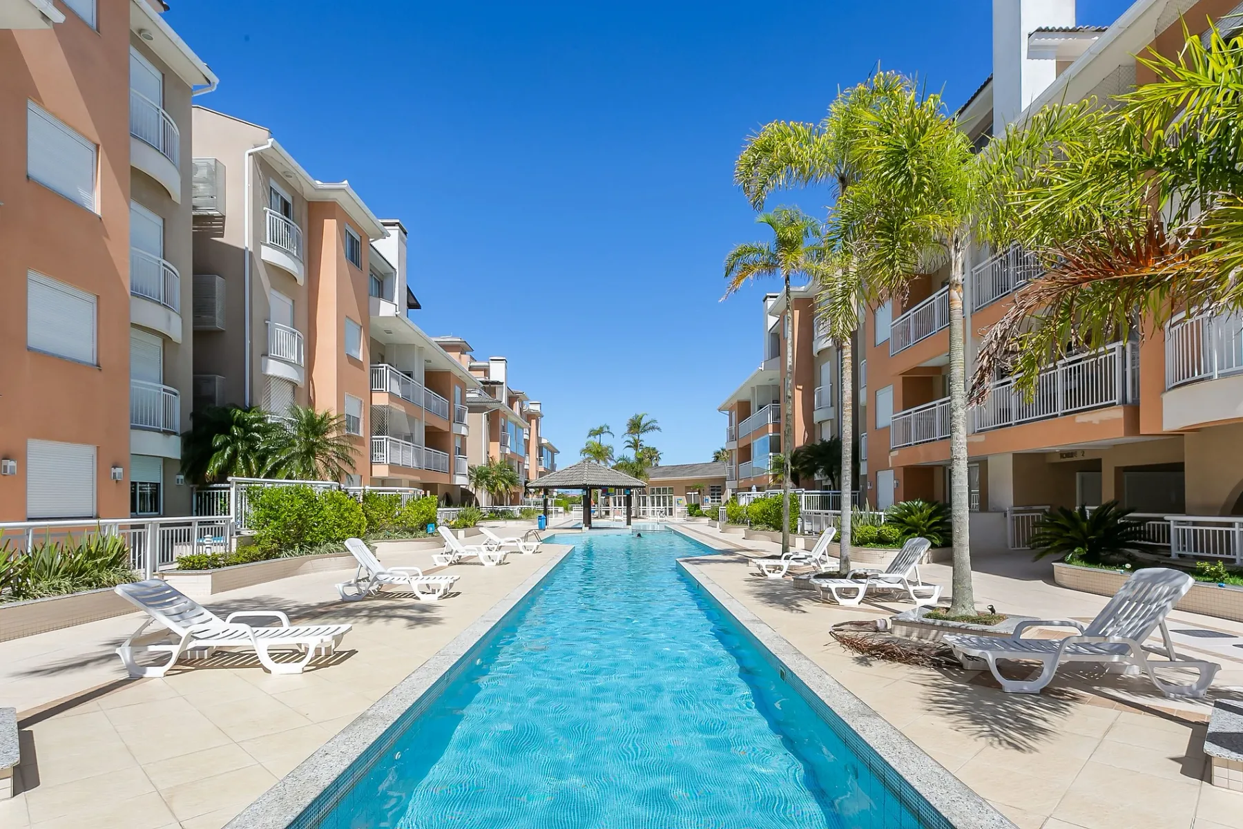 Shared amenity: A swimming pool runs between apartment buildings, with loungers along the deck.
