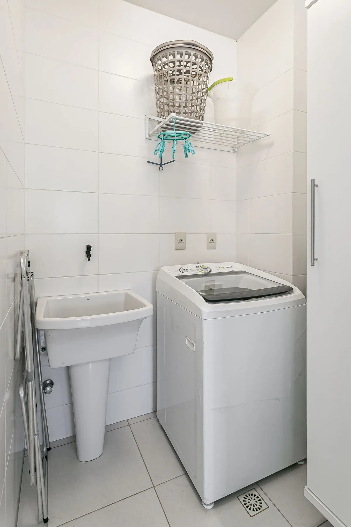 A laundry area with a washing machine and utility sink.
