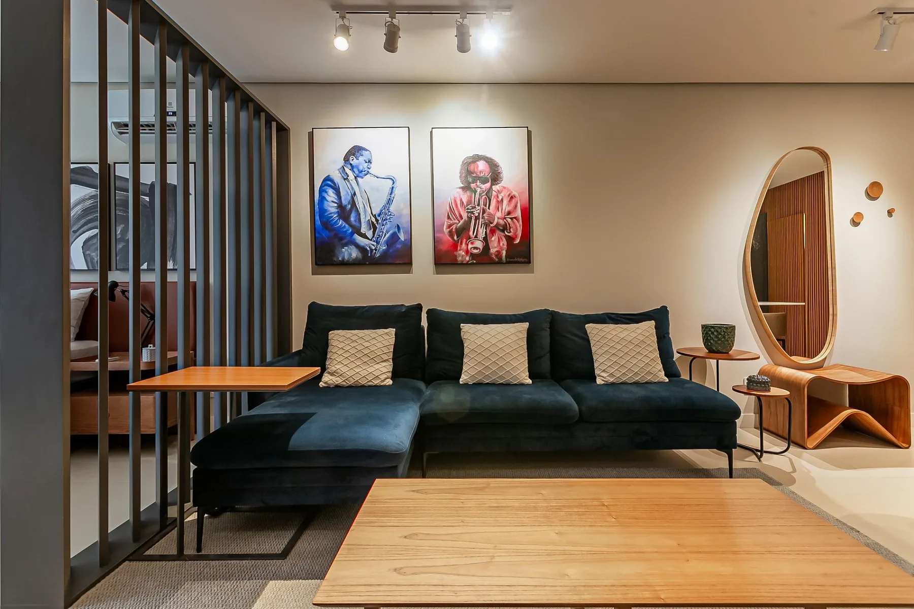 A living room with dark seating, framed artwork, and a wooden coffee table.
