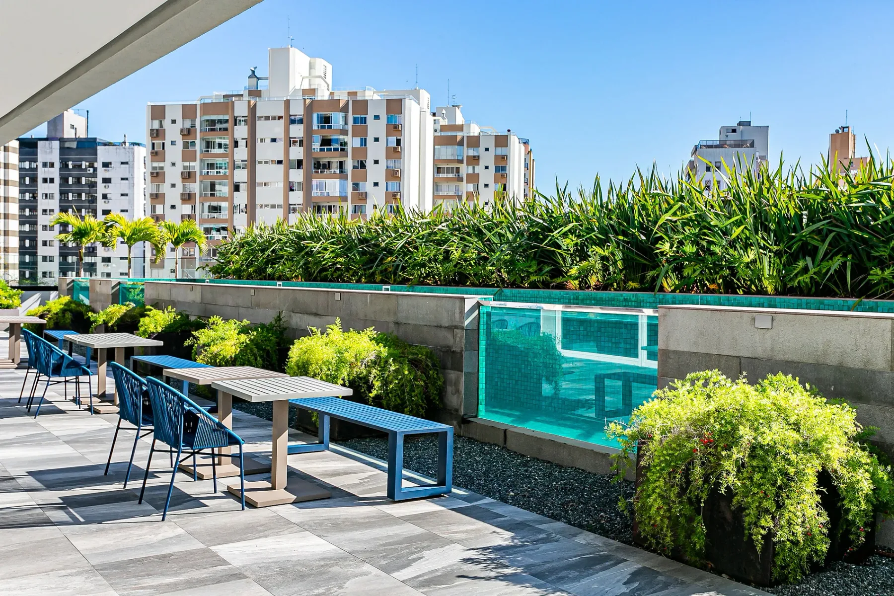 Shared amenity: Outdoor seating area with tables beside a planted terrace.