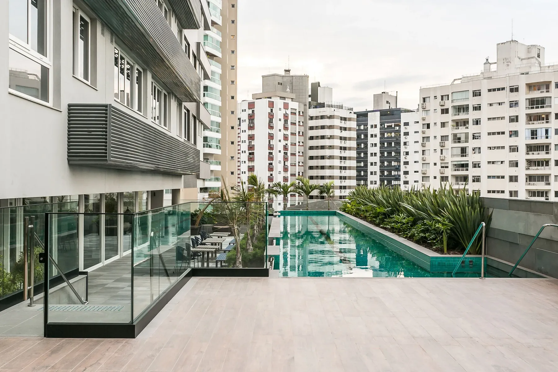 Shared amenity: An outdoor pool beside a paved terrace and surrounding apartment buildings.