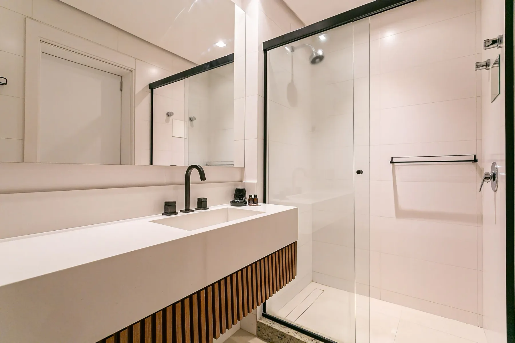 A bright bathroom with a wide sink and glass shower.
