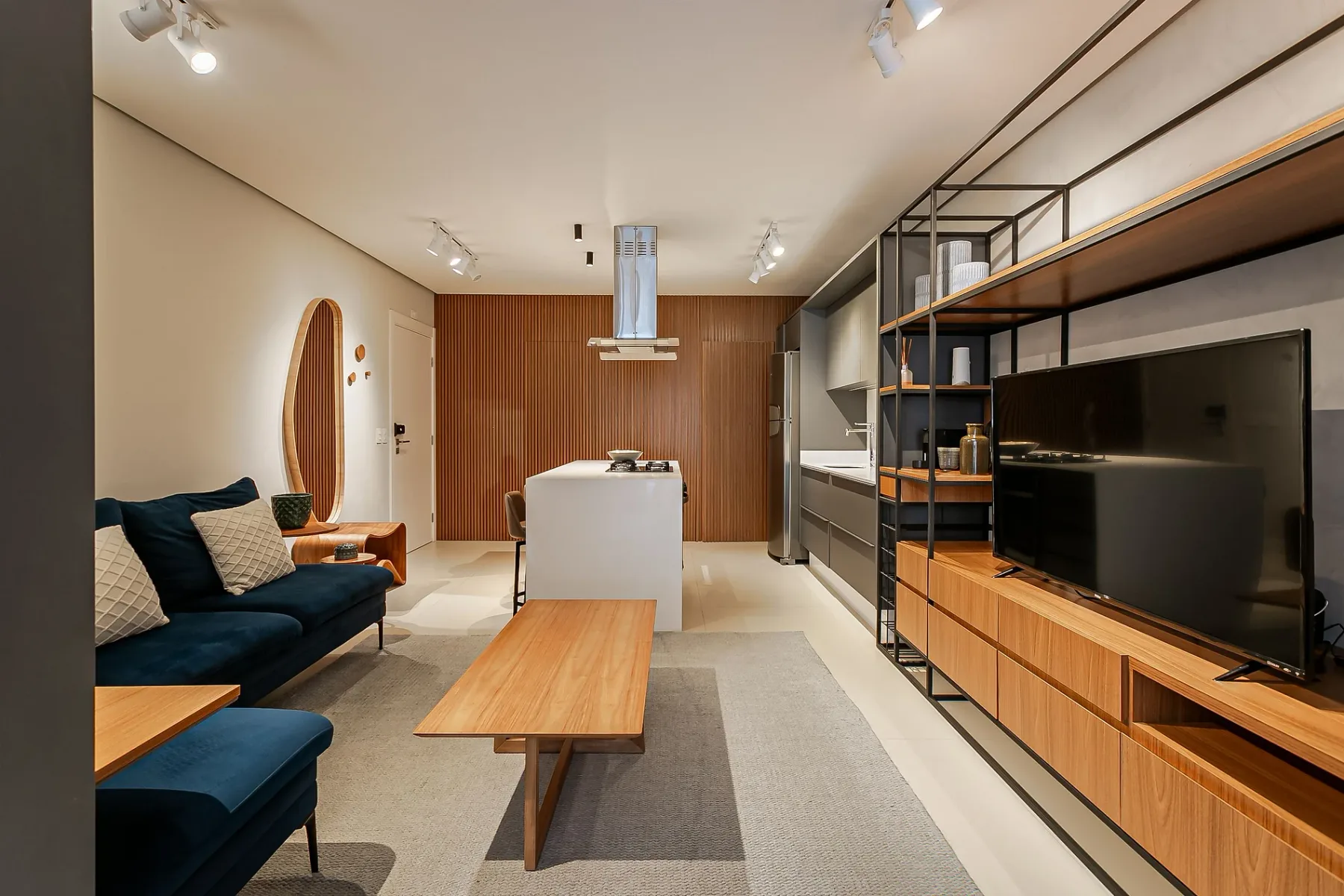 A modern living room with seating, a coffee table, and a television.