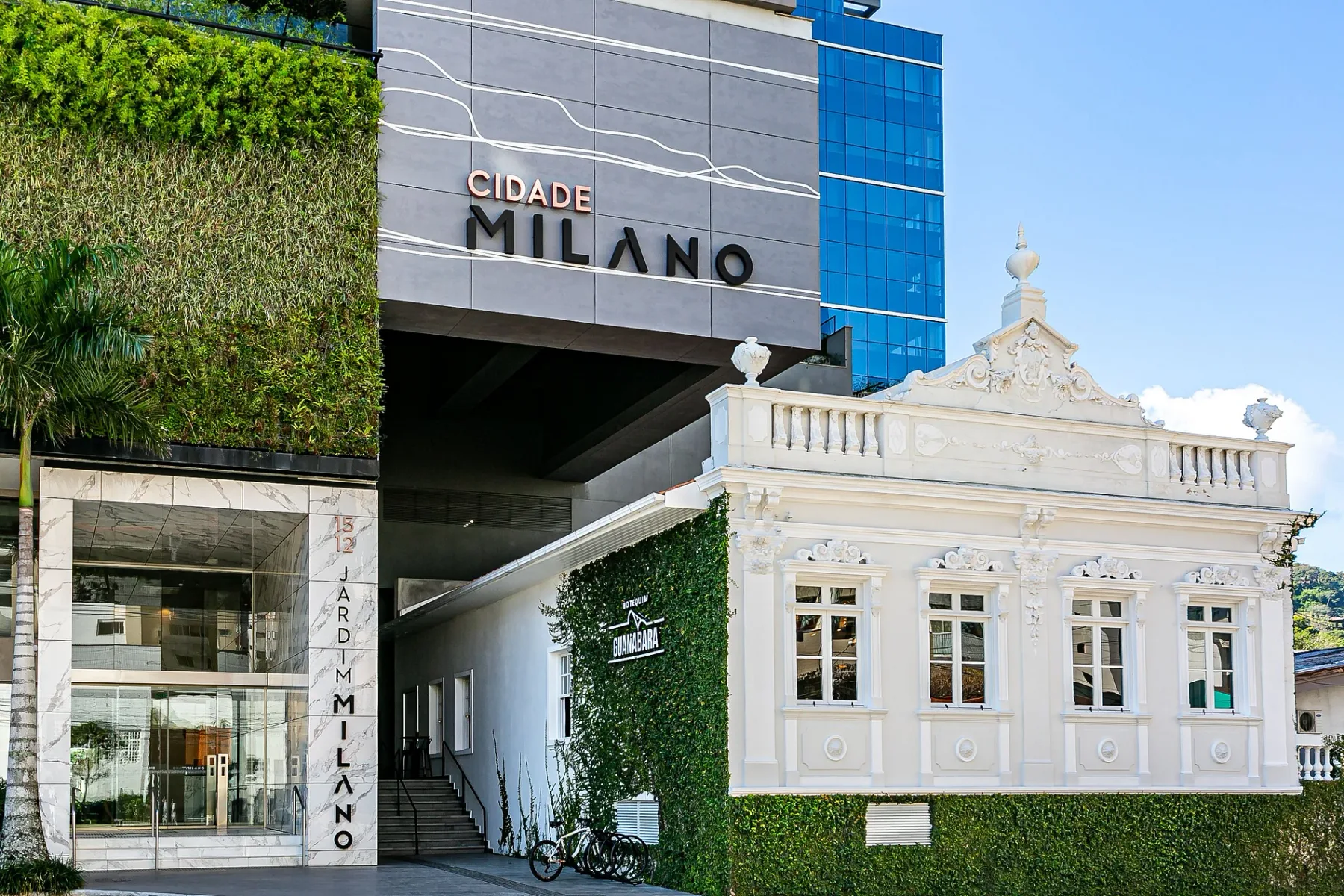 Shared amenity: A modern building stands beside a white historic-style façade and landscaped greenery.