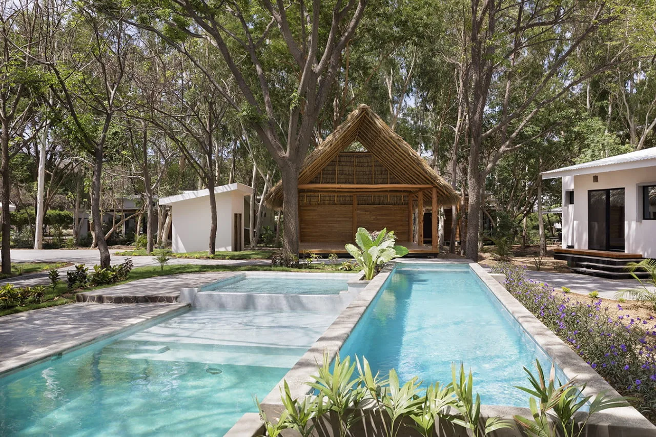 Zona común: Una zona de piscina al aire libre con un pabellón de madera y árboles.