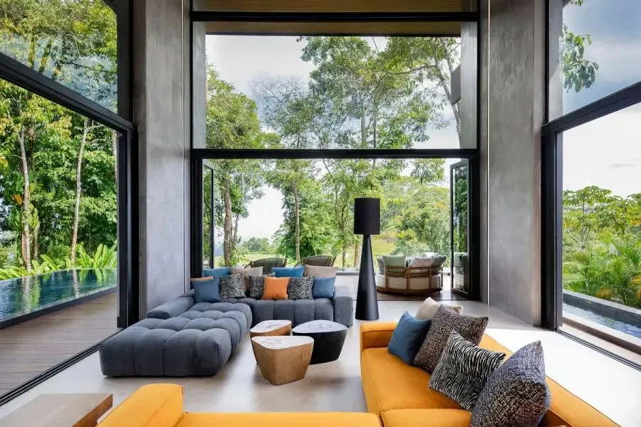 Una sala amplia con asientos junto a grandes ventanales con vistas a la vegetación.