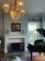 Representative hotel space: A living room features a fireplace and seating beside a large window.