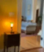 Espacio representativo del hotel: Habitación de hotel iluminada cálidamente, con una cama y una mesa pequeña.