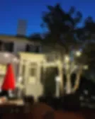 Espacio representativo del hotel: Un patio con asientos al aire libre junto a un edificio bajo y árboles.