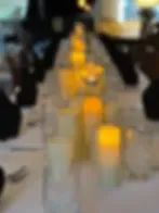 Espacio representativo del hotel: Una mesa de comedor está preparada con vajilla y velas encendidas.