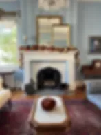 Espacio representativo del hotel: Sala de estar con chimenea y asientos alrededor de una mesa de centro.