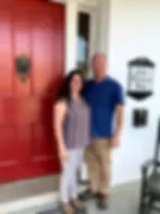 Espacio representativo del hotel: Dos personas están junto a una puerta roja en una entrada iluminada.