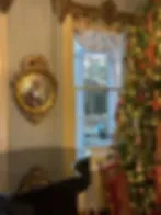 Espacio representativo del hotel: Una habitación con una ventana, cortinas decoradas y arte en la pared.