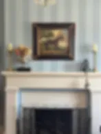 Espacio representativo del hotel: Una habitación con una chimenea bajo un cuadro enmarcado.