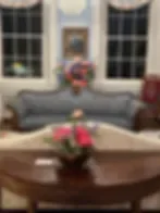 Espacio representativo del hotel: Una zona de estar con asientos curvos y un arreglo floral sobre la mesa.