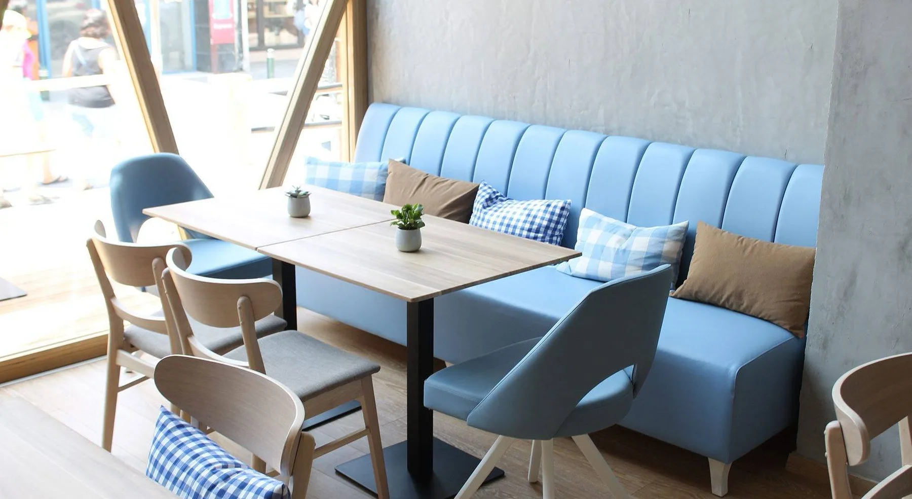 Representative hotel space: A dining area with a long table and blue bench seating.