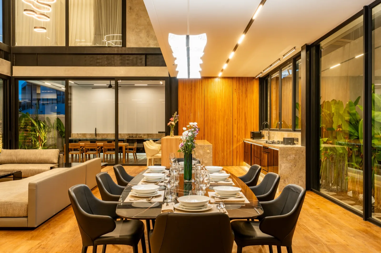 Comedor con una mesa larga preparada para comer junto a una zona de estar.