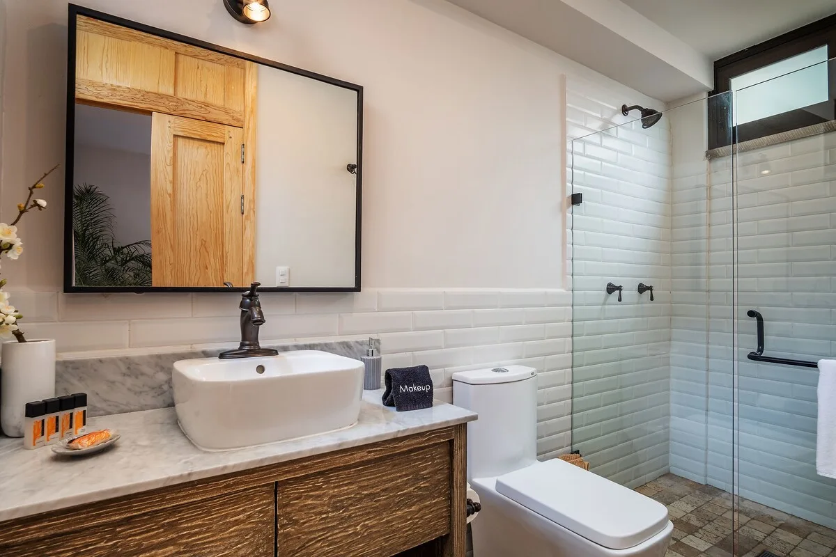 Un baño con lavabo, inodoro y ducha de vidrio.