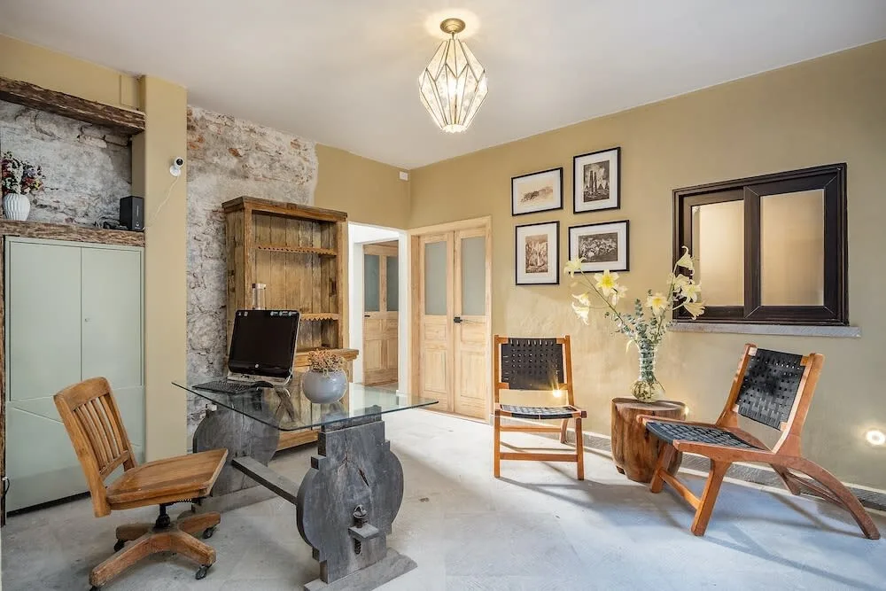 Shared amenity: A sitting area with wooden seating, framed pictures, and a glass table.