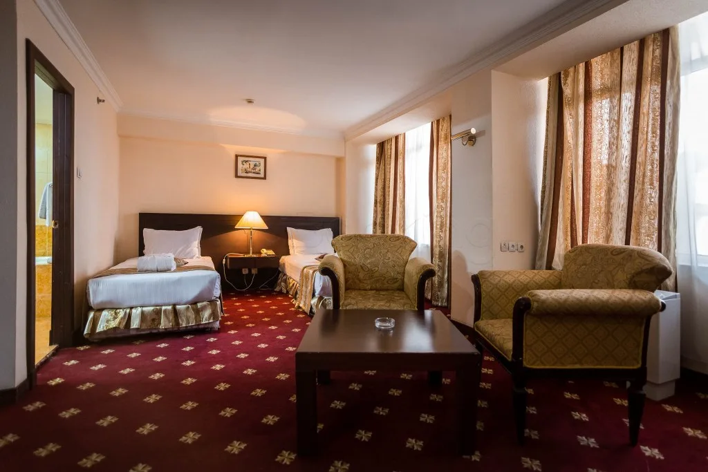 Espacio representativo del hotel: Un dormitorio de hotel con dos camas y una zona de estar.