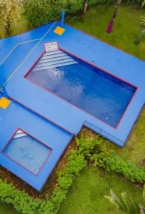 Representative hotel space: A bright blue outdoor pool is surrounded by green landscaping.