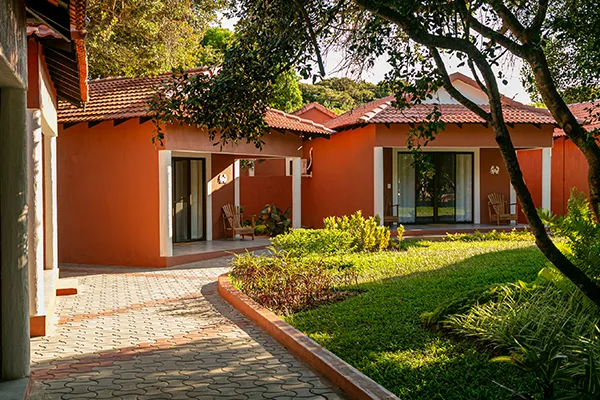 Espacio representativo del hotel: Edificios con tejados rojos rodean un camino pavimentado y un jardín ajardinado.