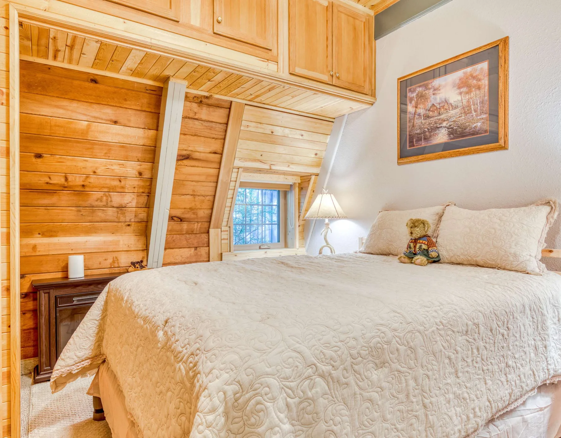 Un dormitorio con una cama grande bajo un techo inclinado de madera.