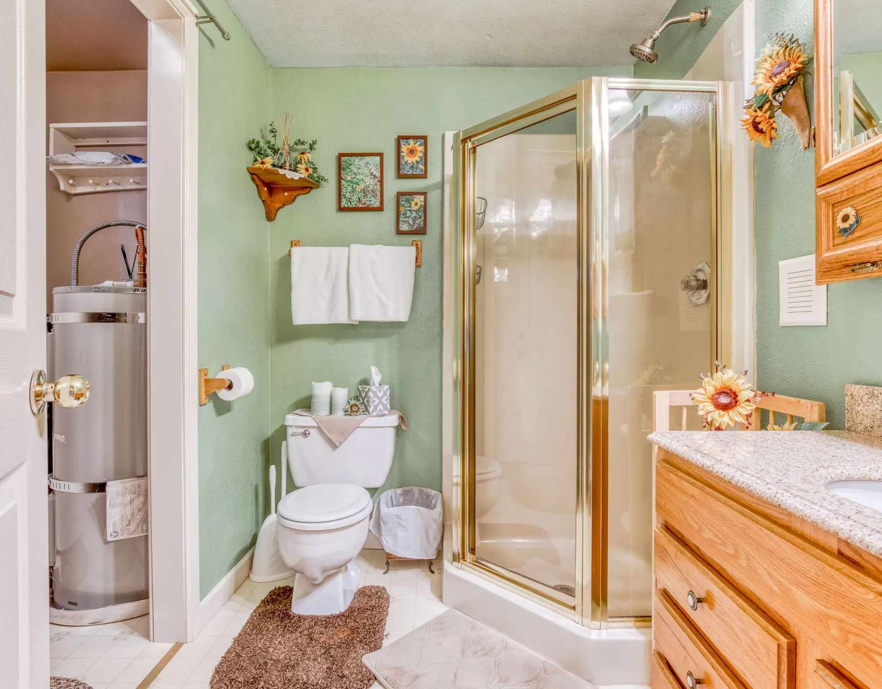 Un baño con ducha de vidrio, inodoro y mueble de madera.