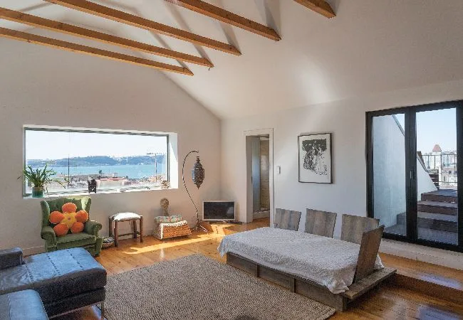 Una luminosa sala de estar y comedor con vistas al agua por las ventanas.