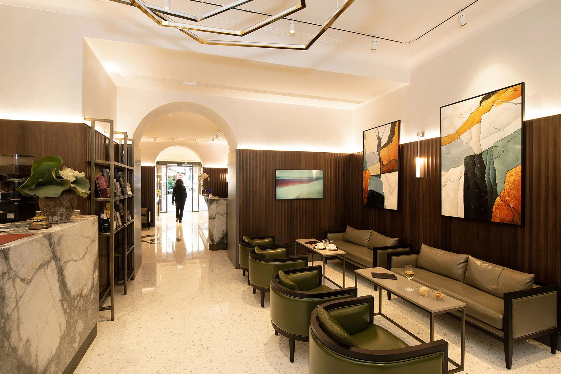 Representative hotel space: A hotel lounge with seating, low tables, and artwork on dark wood walls.