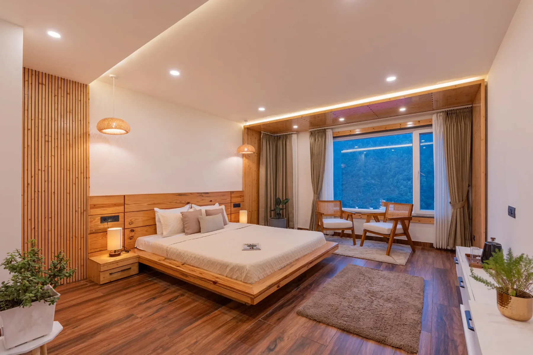 Bedroom with a low bed, wooden flooring, and a window seating area.