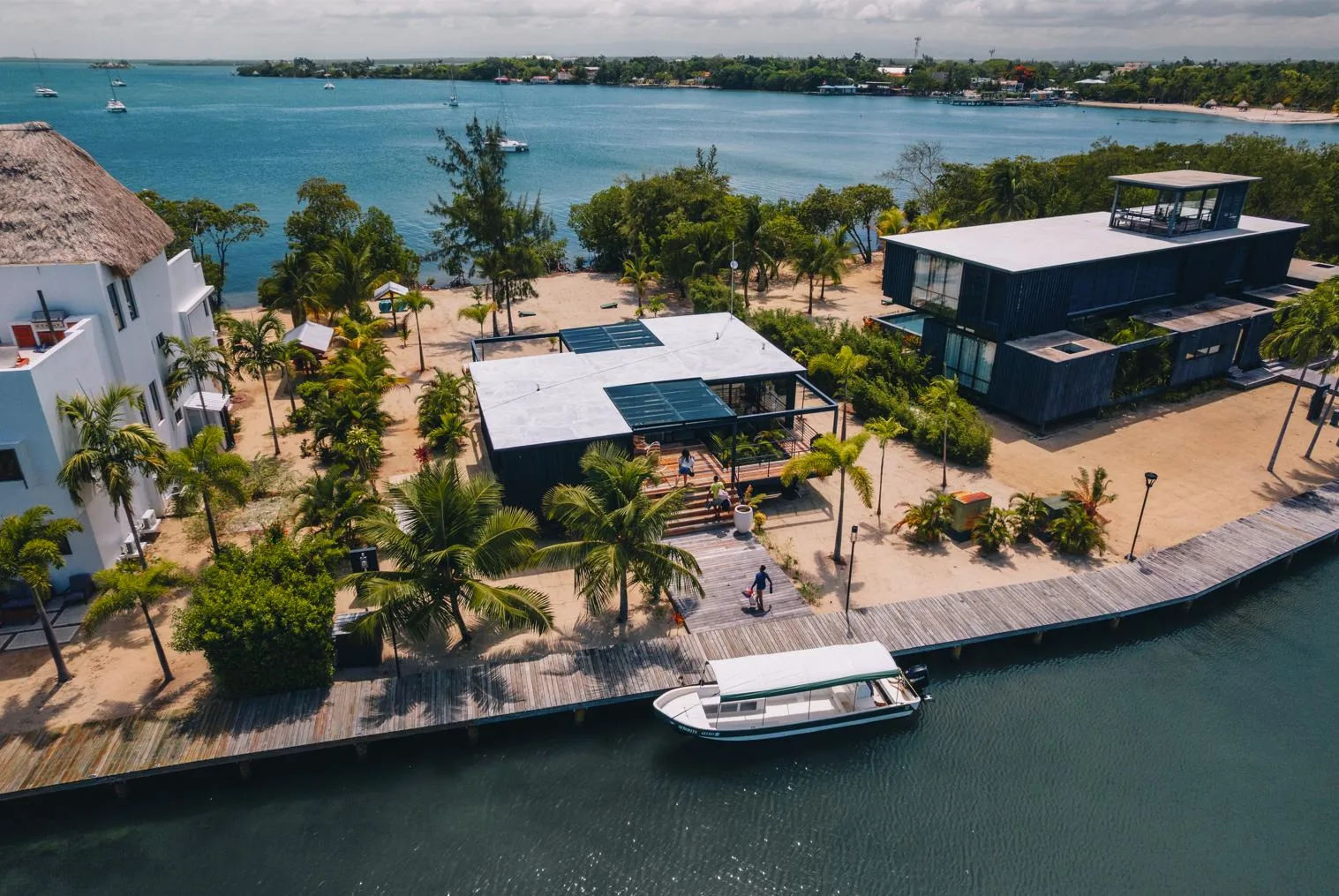 Shared amenity: A waterfront resort complex with low buildings, trees, and a dock along the bay.