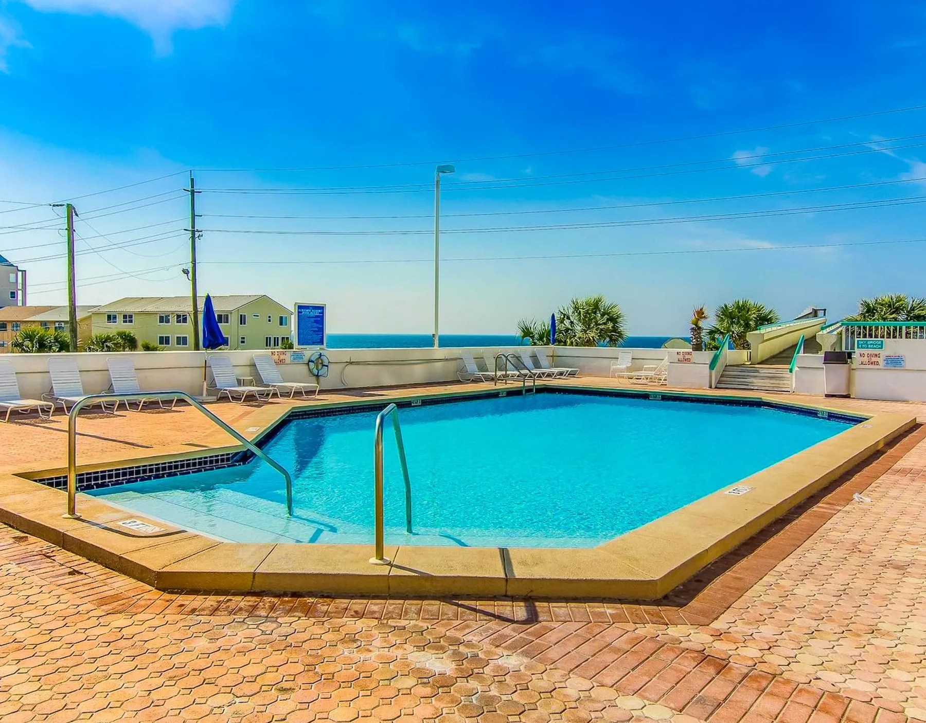 Shared amenity: An outdoor swimming pool sits beside a paved deck and lounge seating.