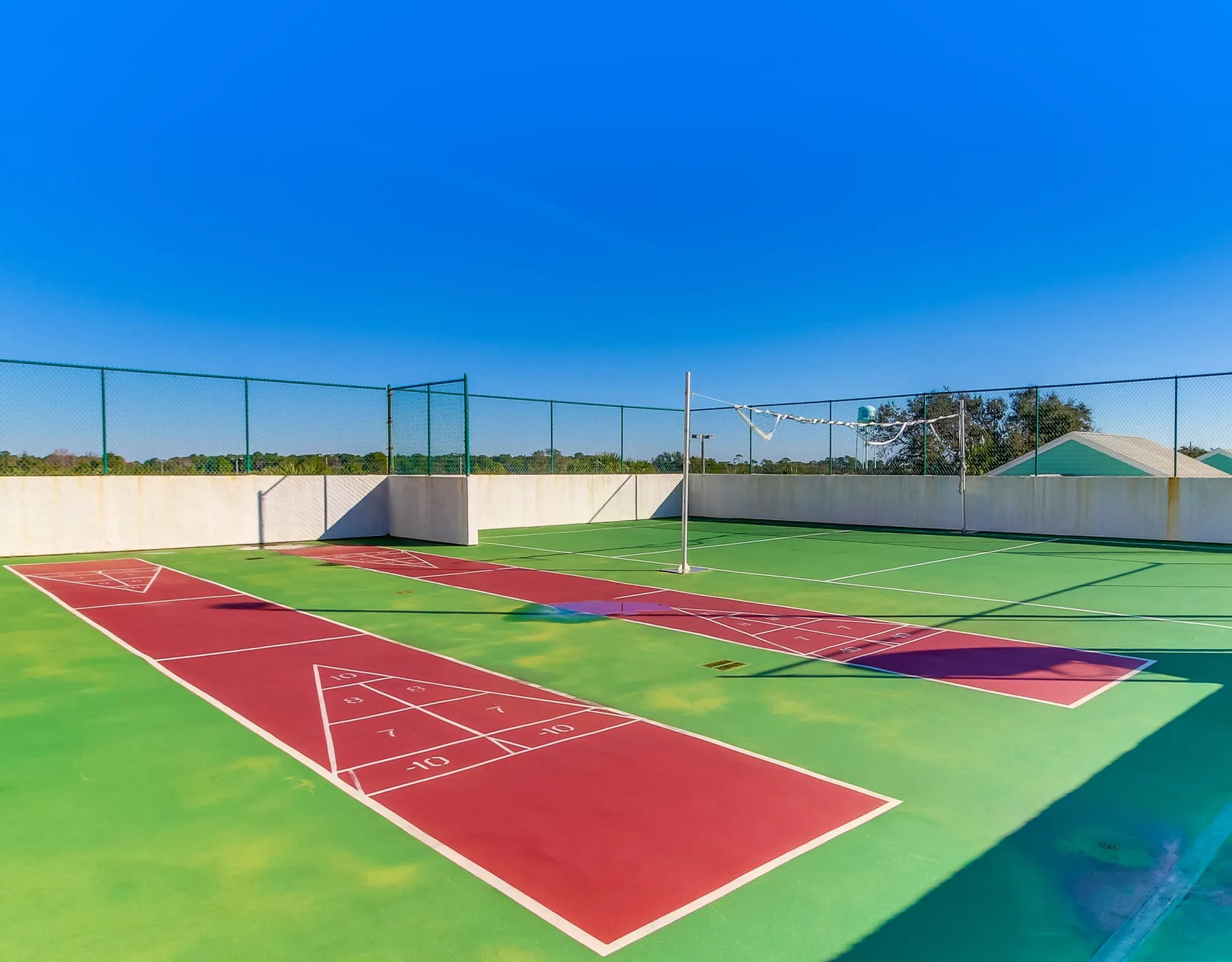 Shared amenity: Outdoor sports court with red and green playing surfaces and a net.