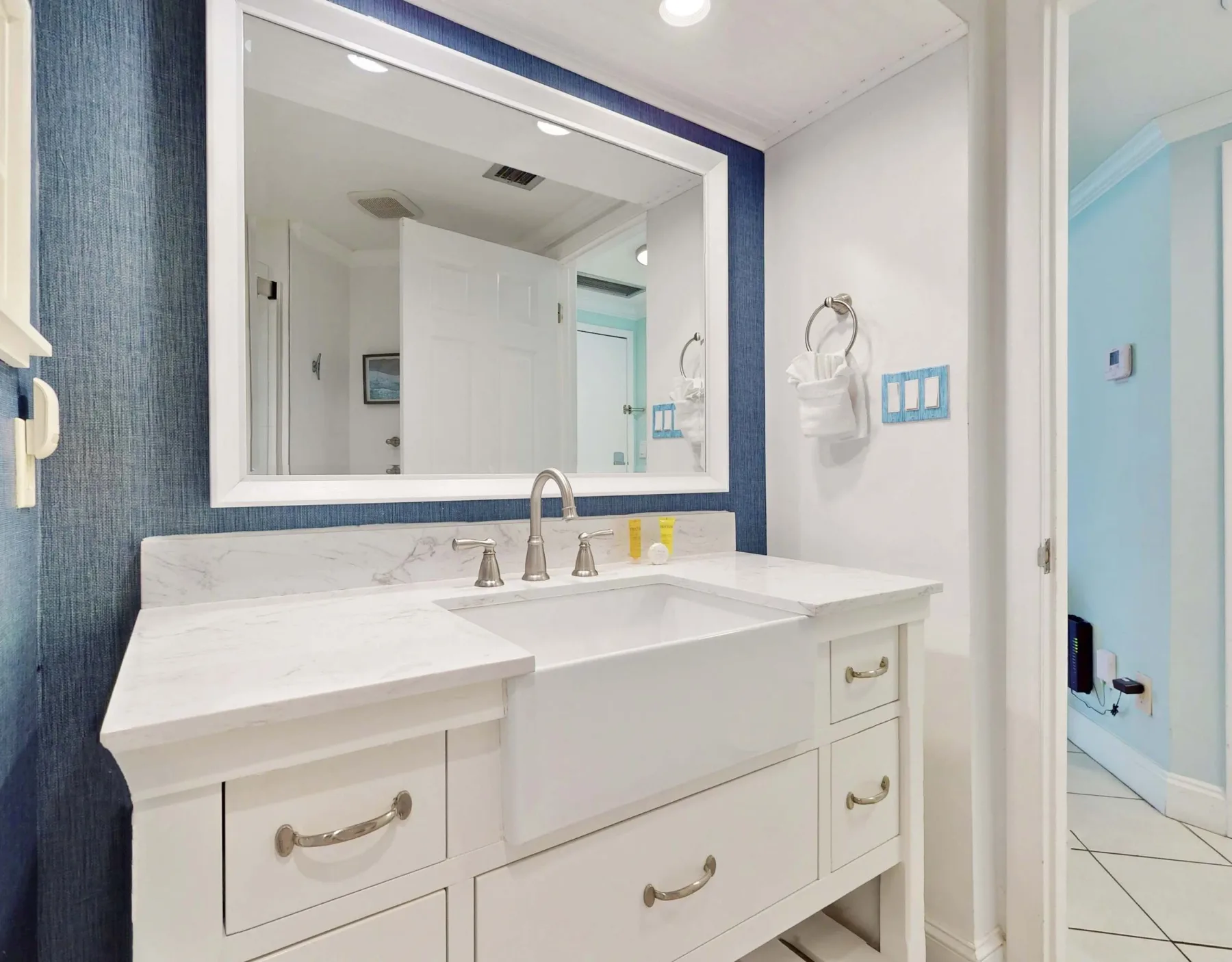 A bathroom vanity with a large mirror and a white sink.