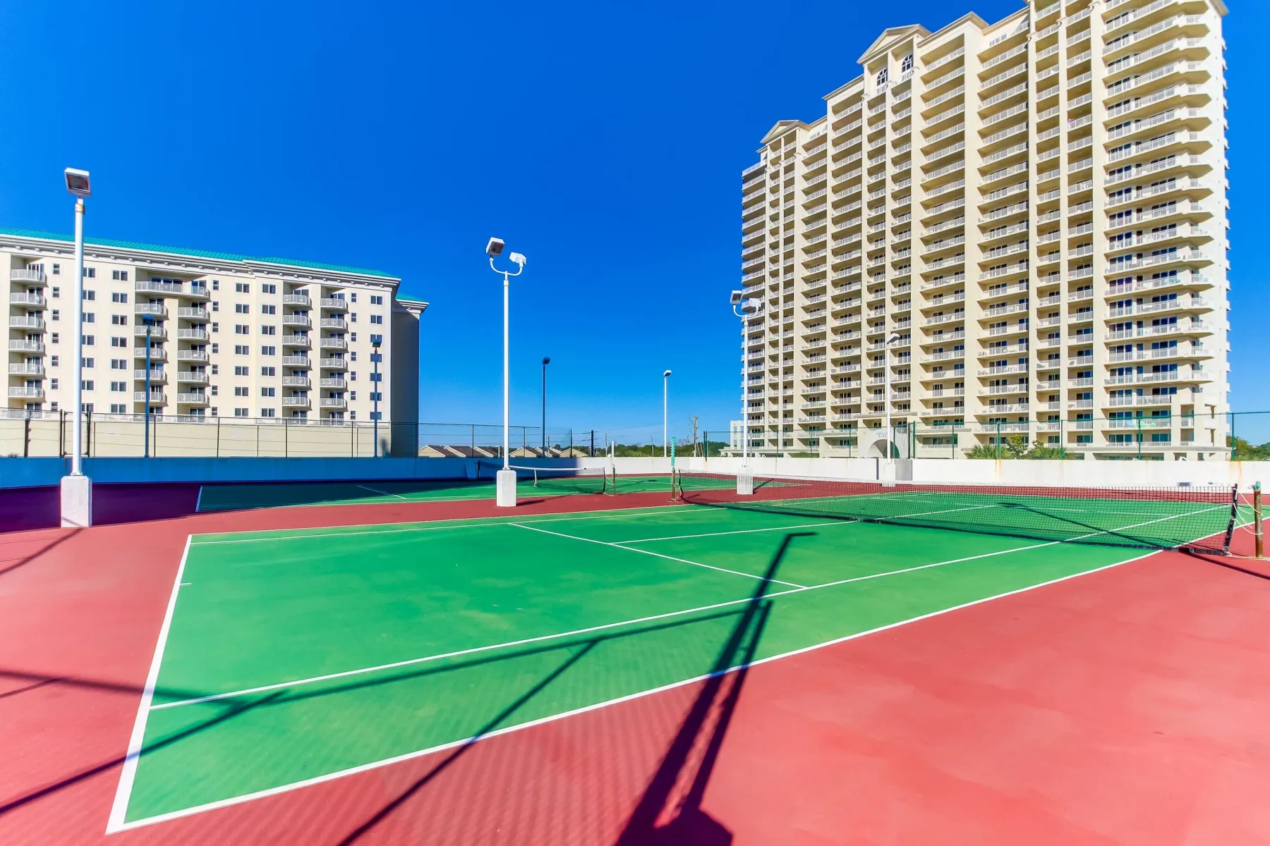 Shared amenity: An outdoor tennis court sits beside several high-rise buildings.