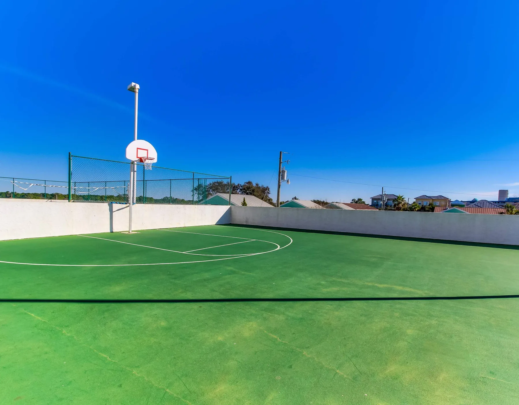 Shared amenity: An outdoor basketball court with a hoop and green playing surface.