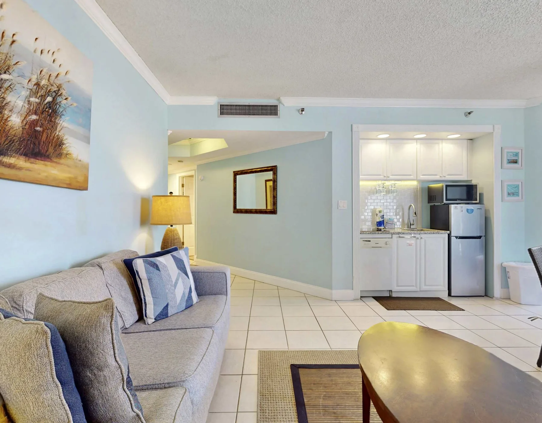 A living area with seating and a compact kitchen in the background.