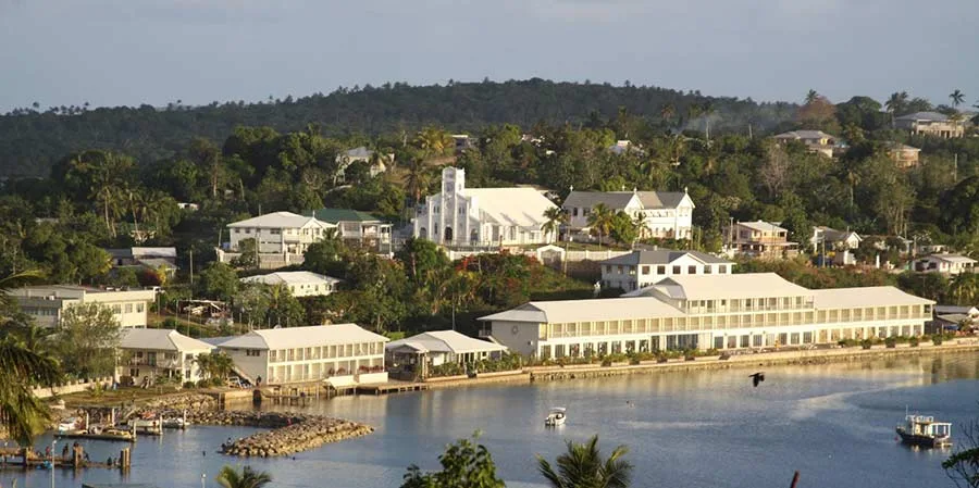 Representative hotel space: A waterfront resort complex stretches along a calm bay beneath a tree-covered hillside.