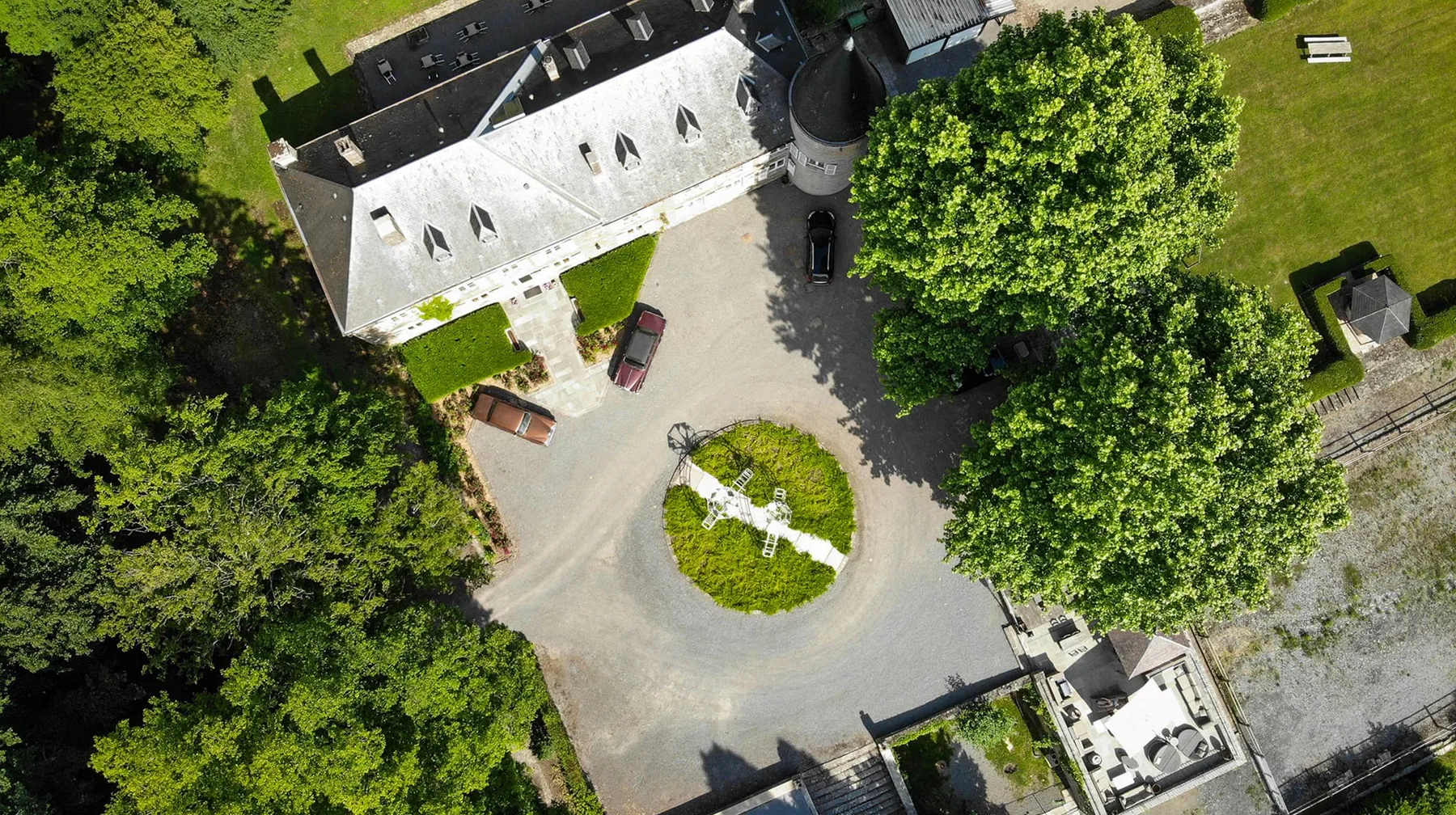 Representative hotel space: An aerial view shows a circular driveway around a landscaped island beside a building.