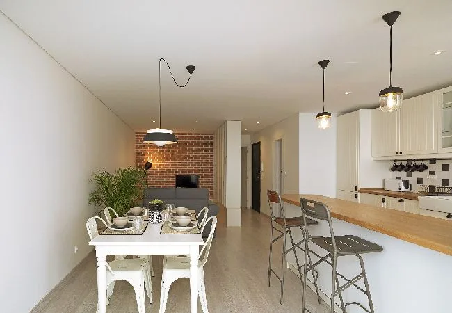 An open-plan dining area and kitchen, with a dining table and counter seating.