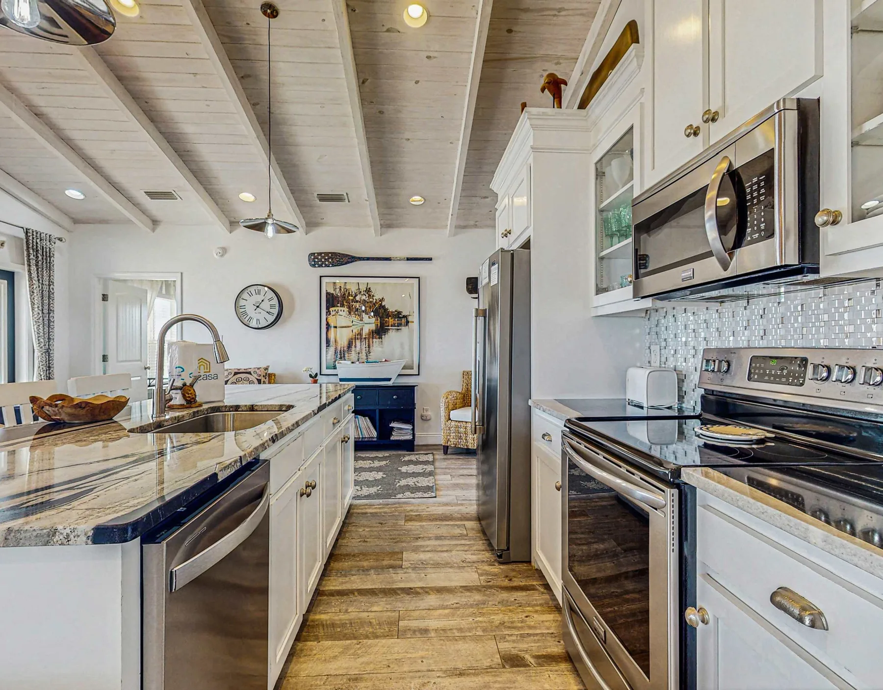 A bright kitchen with white cabinets, a central island, and stainless steel appliances.