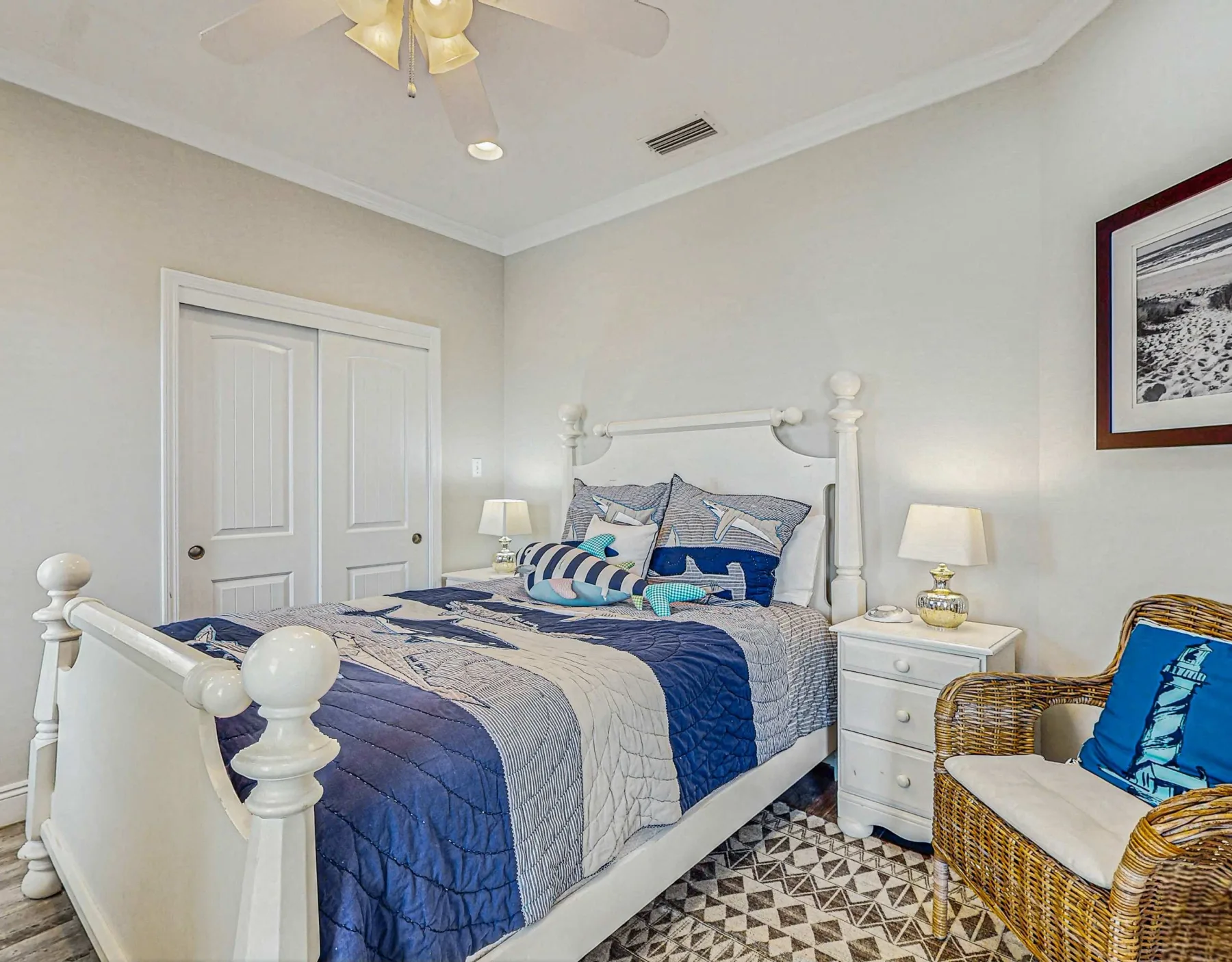 A bedroom with a white bed dressed in blue and white bedding.