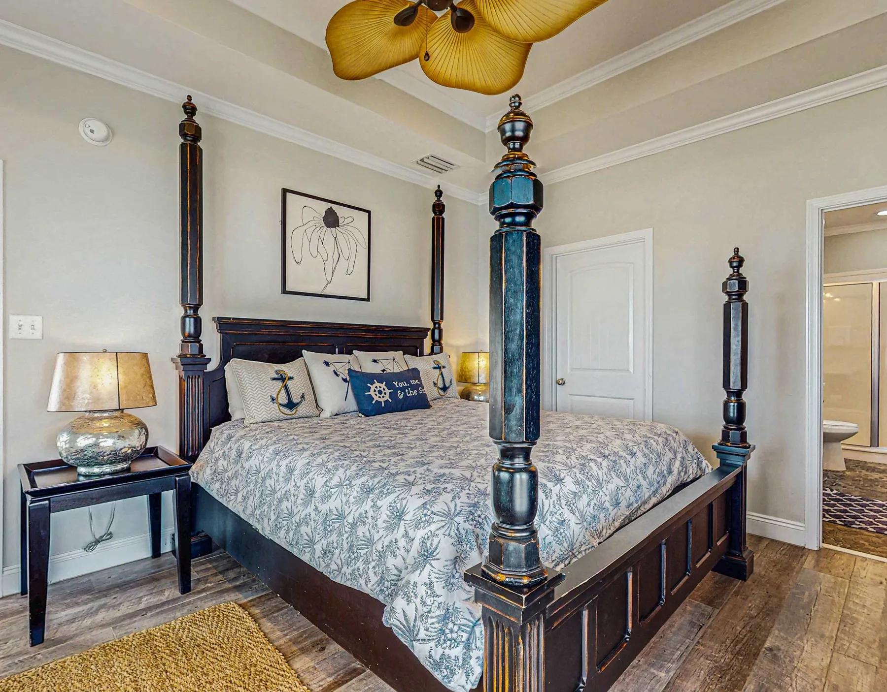 Bedroom with a large dark wood bed, patterned bedding, and a ceiling fan.