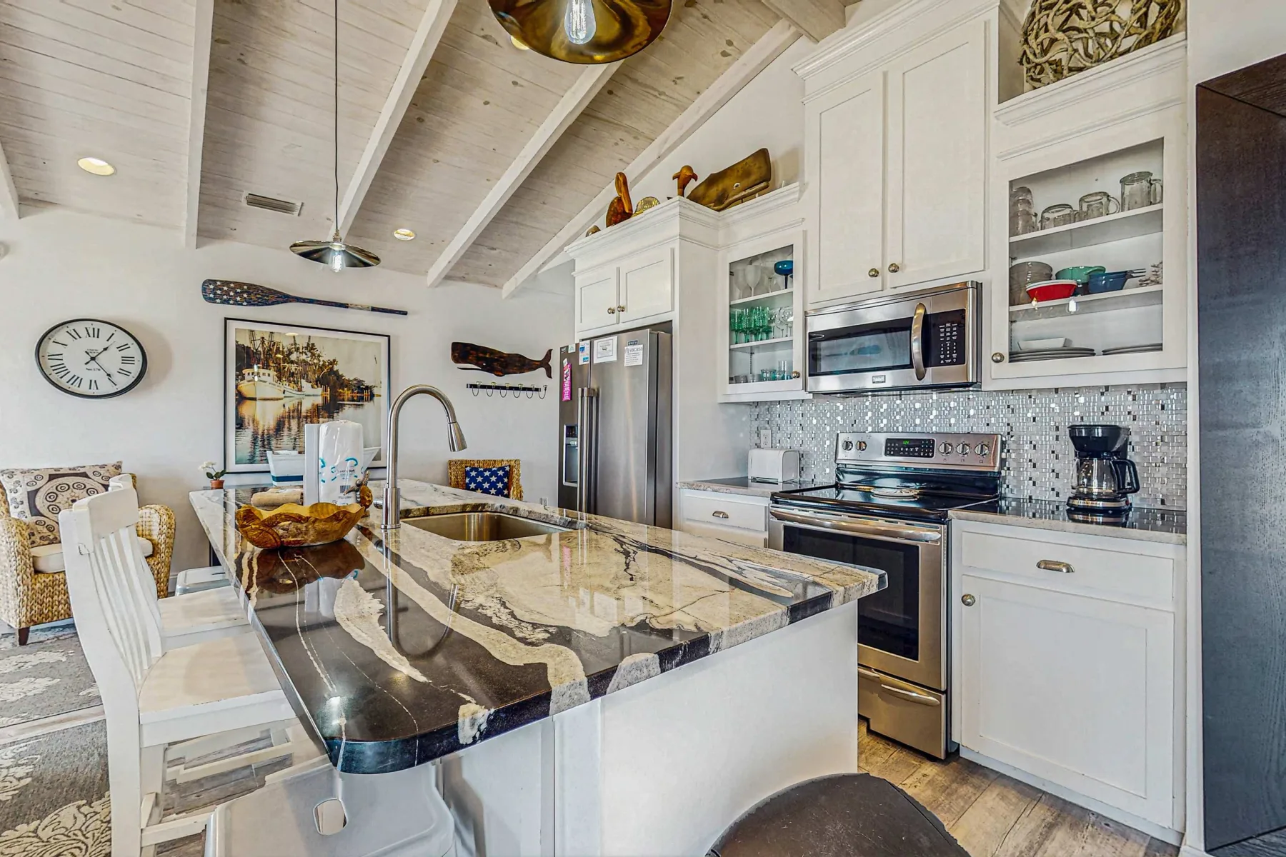 A bright kitchen with a large island and stainless steel appliances.