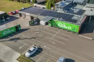 Espacio representativo del hotel: Vista aérea de un estacionamiento comercial con espacios marcados y locales.